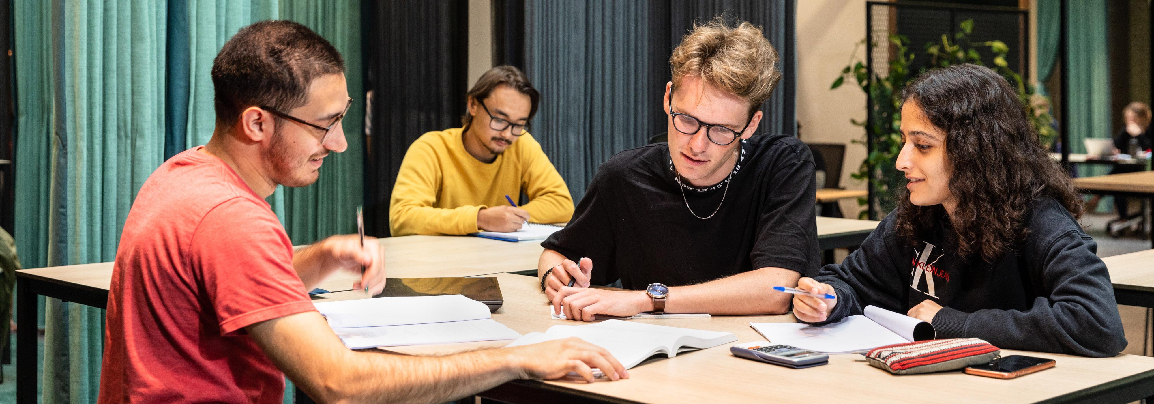 University tutor guiding students during a study session in a classroom